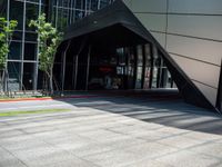 an entrance to a modern office building with a red fire hydrant and large glass windows