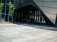 an entrance to a modern office building with a red fire hydrant and large glass windows