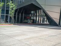 an entrance to a modern office building with a red fire hydrant and large glass windows