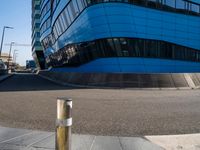 a blue building is on a corner on a city street, with a small gold object in the middle