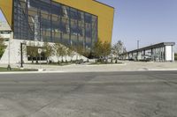 empty asphalt street with a building next to it in front of a building with many windows