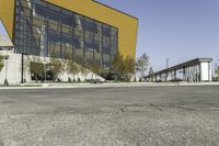 empty asphalt street with a building next to it in front of a building with many windows