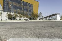 empty asphalt street with a building next to it in front of a building with many windows