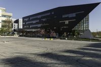 a building with a huge black building in it's center surrounded by several trees