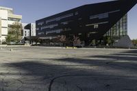 a building with a huge black building in it's center surrounded by several trees