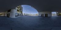 a fish eye view of the entrance to some sort of office building from an arched area of concrete