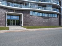 the side of the building has glass windows with curved edges and concrete floors that give it a modern appearance