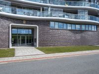 the side of the building has glass windows with curved edges and concrete floors that give it a modern appearance