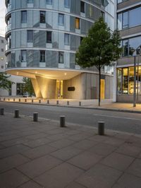 a very neat modern office building with its windows lit up at night next to a road