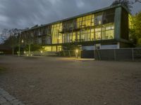 an office building with a gated area and a fence surrounding by it, at twilight