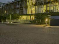 an office building with a gated area and a fence surrounding by it, at twilight