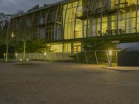 an office building with a gated area and a fence surrounding by it, at twilight