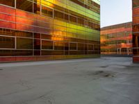 an orange yellow and green building next to each other on top of a road under a clear blue sky