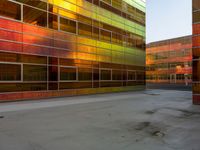 an orange yellow and green building next to each other on top of a road under a clear blue sky