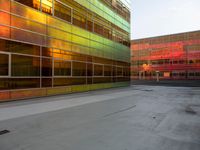 an orange yellow and green building next to each other on top of a road under a clear blue sky