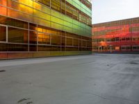 an orange yellow and green building next to each other on top of a road under a clear blue sky