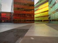 an orange yellow and green building next to each other on top of a road under a clear blue sky