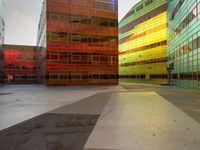 an orange yellow and green building next to each other on top of a road under a clear blue sky