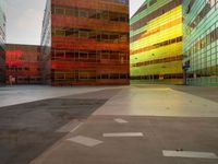 an orange yellow and green building next to each other on top of a road under a clear blue sky