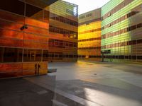 an orange yellow and green building next to each other on top of a road under a clear blue sky