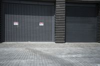 a closed door at a closed storage warehouse in front of a brick wall with a no parking sign