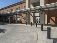 a building with a covered entrance and large windows that overlook it in front of the building