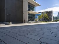 an empty sidewalk next to a very large building with glass windows on the sides of each building