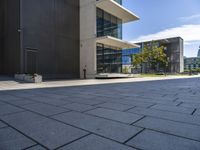 an empty sidewalk next to a very large building with glass windows on the sides of each building