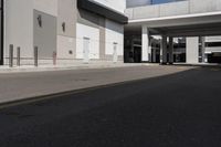 a large gray building with black trim and a parking lot outside, some cars parked in the street