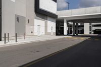 a large gray building with black trim and a parking lot outside, some cars parked in the street