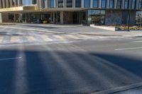 an image of a business building on the corner of a street where there are two traffic lights