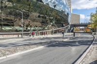 a bus drives by a large building on a busy road with cobblestones around it