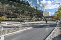 a bus drives by a large building on a busy road with cobblestones around it