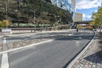 a bus drives by a large building on a busy road with cobblestones around it