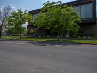 a building with a logo painted on the side near a street that has a sidewalk next to it