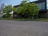 a building with a logo painted on the side near a street that has a sidewalk next to it