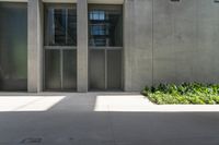 a large concrete building with two double doors and windows in the middle of it's courtyard