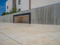 the gray concrete walls of a building have a line of steps on the left side