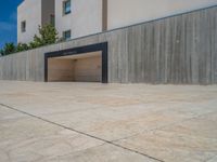 the gray concrete walls of a building have a line of steps on the left side