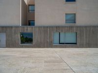 the gray concrete walls of a building have a line of steps on the left side