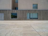 the gray concrete walls of a building have a line of steps on the left side