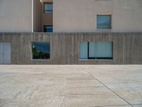 the gray concrete walls of a building have a line of steps on the left side