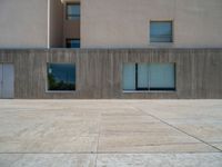 the gray concrete walls of a building have a line of steps on the left side