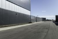 the two buildings are next to each other by a big road side fenced in area