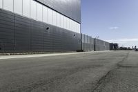 the two buildings are next to each other by a big road side fenced in area