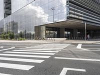 a building with an interesting metal roof sits in the middle of a cross walk in front of it