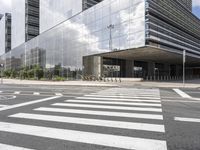 a building with an interesting metal roof sits in the middle of a cross walk in front of it