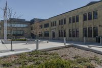 there is an empty courtyard on this large building with lots of green trees on the side