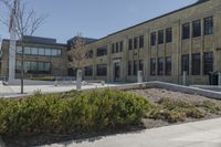 there is an empty courtyard on this large building with lots of green trees on the side