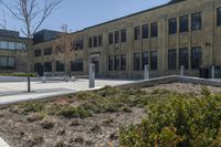 there is an empty courtyard on this large building with lots of green trees on the side